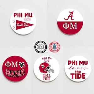 May include: Six round white and red coasters with various designs. The designs include the letters "A" and "ФМ", a heart with the letters "ФМ" and the words "BAMA", a football helmet with the number "18" and the words "PHI MU SAYS ROLL TIDE", and the words "PHI MU loves the TIDE".