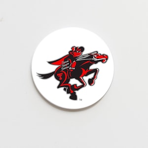 May include: A white, round coaster featuring a red and black illustration of a rider on a horse. The rider wears a cape and hat, and the horse is rearing up. The letter "T" is visible on the horse.