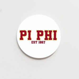 May include: White round sticker with red text that says "PI PHI" with gold glitter outlining the letters. Below the text is "EST 1867" in smaller red letters.