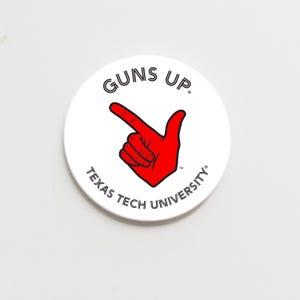May include: A white round button with the words "GUNS UP" in black, arched at the top. A red hand with the index finger pointing up is in the center. The words "TEXAS TECH UNIVERSITY" are in black, arched at the bottom.