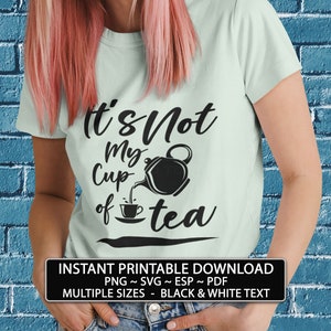 May include: A light blue t-shirt with black text that reads "It's Not My Cup of Tea" with a black teapot pouring tea into a teacup. The text is in a handwritten font. The t-shirt is being worn by a person with pink hair. The image includes the text "INSTANT PRINTABLE DOWNLOAD PNG ~ SVG ~ ESP ~ PDF MULTIPLE SIZES - BLACK & WHITE TEXT".