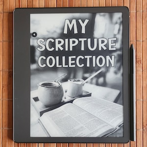 May include: A black and white image of an e-reader displaying the text "MY SCRIPTURE COLLECTION". The e-reader is on a wooden surface and there is a book and a teacup in the background.