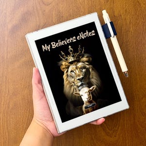 May include: A white digital e-reader tablet featuring a screen display of a lion wearing a gold crown with a lamb positioned in front, and the text My Believers eNotes. A white stylus is attached to the side of the device in a dark blue holder.