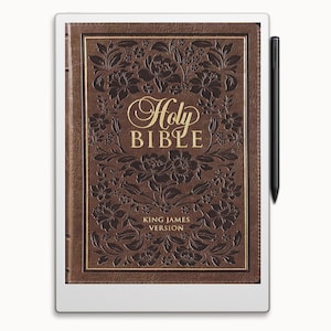 May include: A white e-reader with a brown leather cover displaying a digital version of the Holy Bible, King James Version. The cover features an embossed floral design and gold lettering.