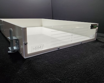 May include: White plastic tray with a clear plastic insert and a level. The insert has markings for 1/2 inch, 1 inch, 1 1/2 inches, and 2 1/2 inches. The tray has the text "MRM/" printed on the side.