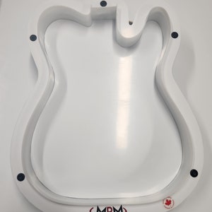 May include: White plastic guitar body template with a black outline and black screws. The template has the logo "MRM" printed on the bottom.