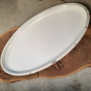 May include: White oval-shaped tray with a raised edge and a (MRM) logo. The tray is sitting on a wooden surface.