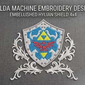 Könnte beinhalten: Ein Maschinenstickdesign eines Hylian-Schildes mit blauem Zentrum, rotem Vogel-Emblem und gelben Dreiecken, umgeben von weißem Filigran. Der Text lautet ZELDA MACHINE EMBROIDERY DESIGN EMBELLISHED HYLIAN SHIELD 4x4.