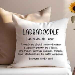 May include: White throw pillow with black text that reads "LABRADOODLE | lab-ra-doo-dle | noun" and a definition of the word. The definition reads "A lovable and playful crossbreed between a Labrador Retriever and a Doodle. Very friendly, extremely intelligent, energetic, loyal, affectionate and the perfect companion. Synonyms: doodle, dood"