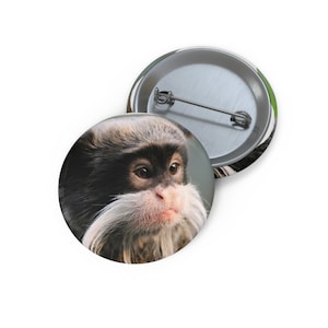 May include: A close-up of a small monkey with black fur and a white beard. The monkey has large, dark eyes and a pink nose. The monkey is looking to the right of the image.