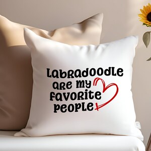 May include: White pillow with the text "Labradoodle are my favorite people" in black font and a red heart.