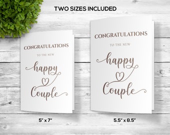 May include: Two sizes of white greeting cards with the text "Congratulations to the new happy couple" in brown cursive script with a heart symbol. The card sizes are 5 inches by 7 inches and 5.5 inches by 8.5 inches.