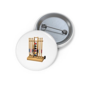 Könnte beinhalten: Ein hölzernes Krocket-Set mit Schlägern und Bällen. Das Set steht auf einem Holzständer mit Rädern. Die Bälle sind rot, gelb, blau und schwarz.