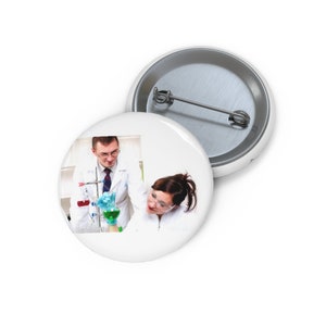May include: Two people wearing white lab coats are working in a laboratory. One person is pouring a green liquid from a beaker into another beaker. The other person is looking at the beaker with a curious expression.