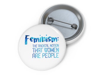Pode incluir: Botão branco com texto azul que diz "Feminismo: A noção radical de que as mulheres são pessoas."
