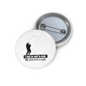 May include: White button with a black silhouette of a person fishing. The text reads "I had to call in sick My arm is in a cast."