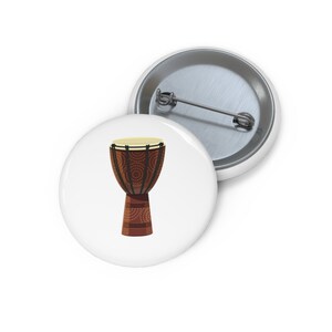 May include: A brown wooden djembe drum with a white and black patterned design. The drum has a natural wood finish and a light brown leather head.