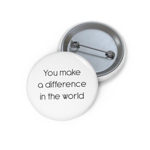 May include: White button with the text "You make a difference in the world" printed in black.
