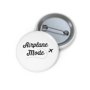 May include: White button with black text that reads "Airplane Mode" with a small airplane icon and a dotted line trail behind it.