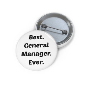 May include: White button with black text that reads "Best. General Manager. Ever."