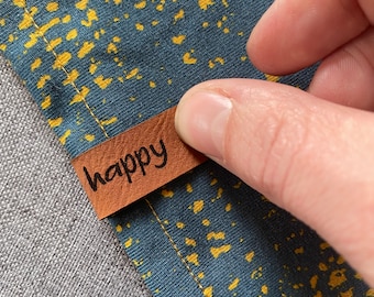 Kunstleder Saumlabel "happy" in braun oder grau