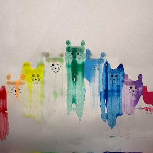 Puede incluir: Un arcoíris de huellas de patas de gato de colores con detalles en marcador negro sobre un fondo blanco.