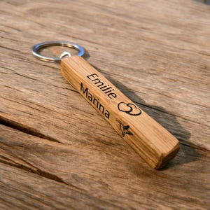Handgemaakte houten sleutelhanger met gepersonaliseerde lasergravure: elegant en praktisch accessoire.