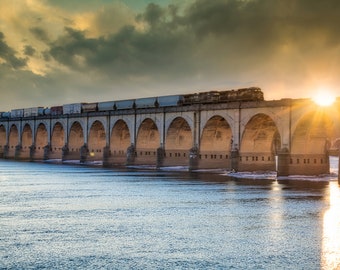 A print or canvas of A train going over the Susquehanna River into Harrisburg PA at sunset