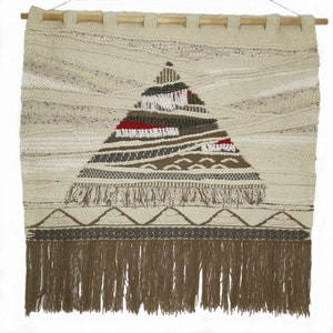 May include: A beige woven wall hanging with a brown, white, and red geometric design in the center. The hanging has a fringe border.