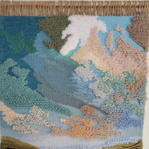 K&ouml;nnte beinhalten: Ein gewebter Wandbehang mit einem abstrakten Design in Blau, Gr&uuml;n und Beige. Das Design verf&uuml;gt &uuml;ber eine Vielzahl von Texturen und Farben, die einen einzigartigen und modernen Look erzeugen.