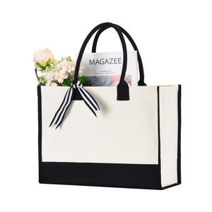 a black and white bag with a flower in it