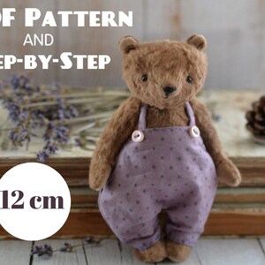 May include: A PDF pattern and step-by-step instructions for sewing a 12 cm brown teddy bear wearing purple overalls with white polka dots.