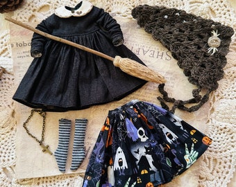 May include: A black witch's dress with a white collar, a broom, a pair of striped socks, and a black and white Halloween-themed skirt with ghosts, pumpkins, and bats.