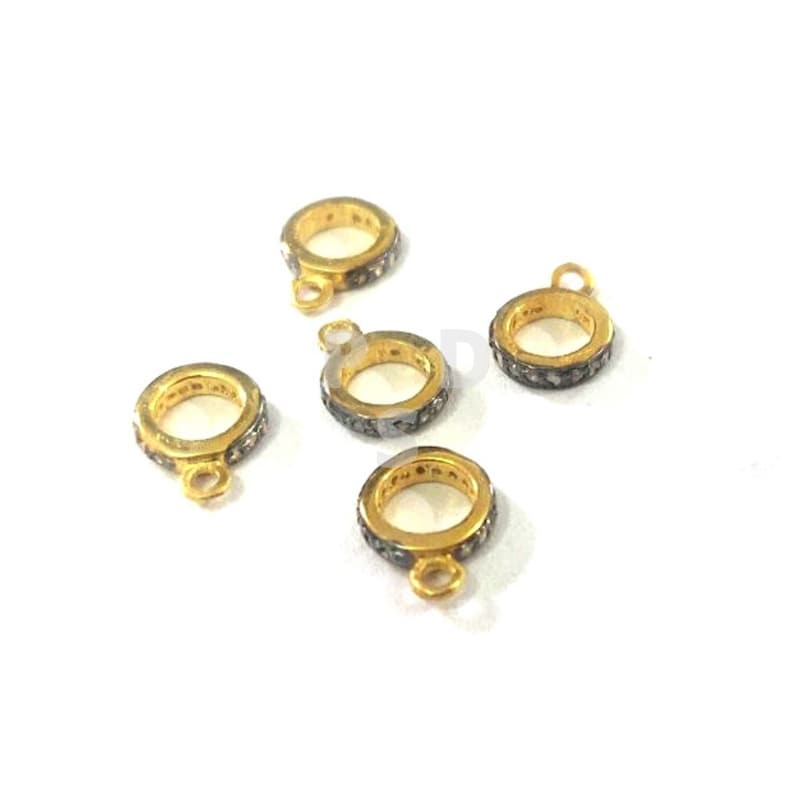 May include: Five gold-toned rings with a black diamond-like stone encrusted band. Each ring has a small loop attached to the side.
