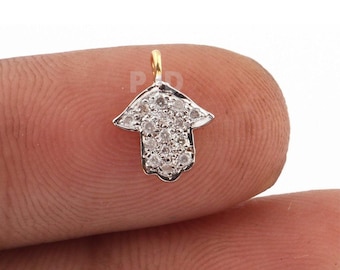May include: A silver hamsa hand charm with a gold bail and a pave setting of clear cubic zirconia stones.