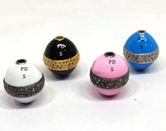 May include: Four round beads with a black, white, pink, and blue enamel finish. Each bead has a band of small diamonds around the center. The beads are labeled "PD S".