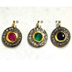 May include: Three gold pendants with a black and silver setting. The pendants feature a red, green, and blue gemstone in the centre.