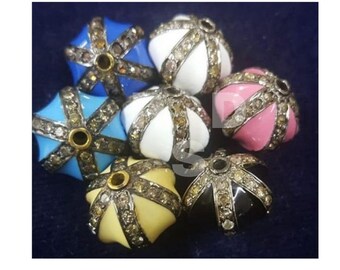 May include: Assortment of round, multi-colored beads with a starburst design. Each bead is decorated with small, clear gemstones and has a gold-colored center hole.