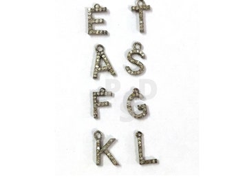 May include: A set of nine silver letter charms, each letter is encrusted with small diamonds. The letters are: E, T, A, S, F, G, K, and L.