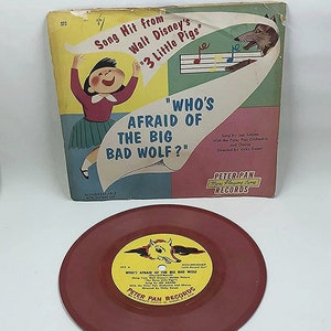 May include: A red 7-inch vinyl record with a yellow label featuring a cartoon wolf. The label reads "Who's Afraid of the Big Bad Wolf?"  Song Hit from Walt Disney's "3 Little Pigs".  Peter Pan Records.  More Playing Time Records.