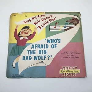 May include: A vintage record sleeve featuring a cartoon illustration of a girl and a wolf. The record is from Walt Disney's "3 Little Pigs" and features the song "Who's Afraid of the Big Bad Wolf?" by Lee Adams. The record is a Peter Pan More Playing Time record.