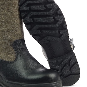 Puede incluir: Una bota alta con una secci&oacute;n inferior de cuero negro texturizado y una ca&ntilde;a superior de lana afieltrada gris. La suela de goma negra tiene un patr&oacute;n de tacos profundos para mayor tracci&oacute;n, con el n&uacute;mero 43 grabado en el centro.