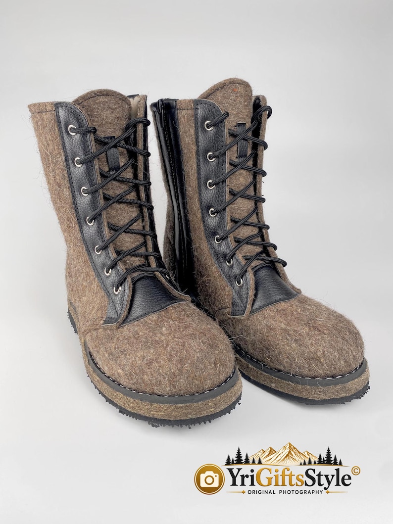 May include: A pair of mid-calf boots featuring a textured brown felted wool upper combined with black leather accents. The boots include black laces threaded through silver-toned metal eyelets, a black side zipper, and a thick, dark, textured rubber sole.
