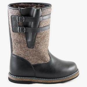 Puede incluir: Botas de cuero negro y fieltro gris con cierre de hebilla. Las botas tienen una suela gruesa de goma.