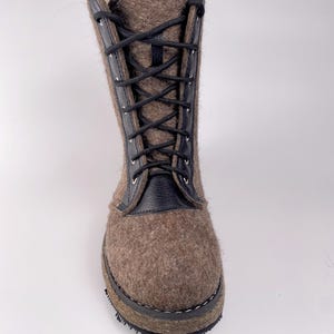 May include: A mid-calf boot crafted from brown felted wool with black leather trim along the lace-up front. The boot features black laces threaded through silver-toned metal eyelets and a thick, dark-colored sole. The text YriGiftsStyle is visible.