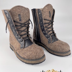 May include: A pair of brown felt boots featuring black leather trim, black laces, and black side zippers. The boots have a textured brown wool-like exterior, black metal eyelets, and a thick black rubber sole with visible stitching detail.