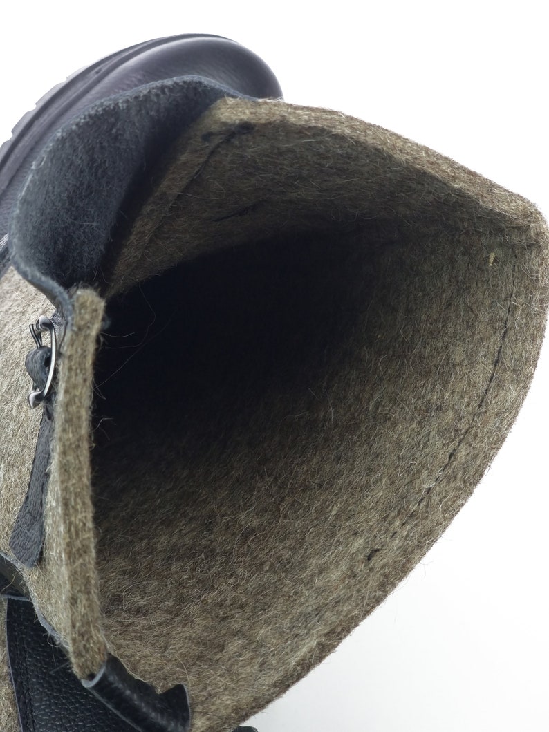 Puede incluir: Una bota alta con exterior de cuero marr&oacute;n oscuro y un forro grueso de lana afieltrada de color marr&oacute;n claro con textura. La bota tiene un ojal met&aacute;lico visible para los cordones y una suela de goma resistente de color marr&oacute;n oscuro.