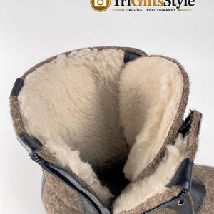 May include: A brown felt boot with a thick, cream-colored wool lining. The boot features a black zipper closure along the side, black trim detailing, and a textured exterior surface. The interior is fully lined with soft, light-colored wool.
