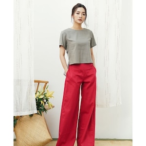May include: A woman is wearing a gray short-sleeved top and wide-legged red pants.