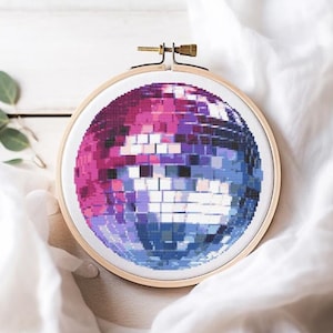 May include: A pink and blue disco ball cross-stitch embroidery hoop.